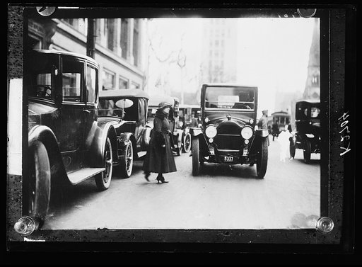 Woman walking in front of automboiles, Mich.