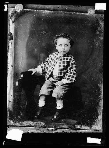 Seated boy in checkered jacket