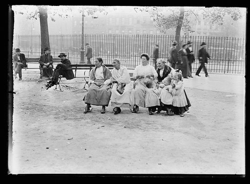 Four women with three children sitting on bench, possibly at park