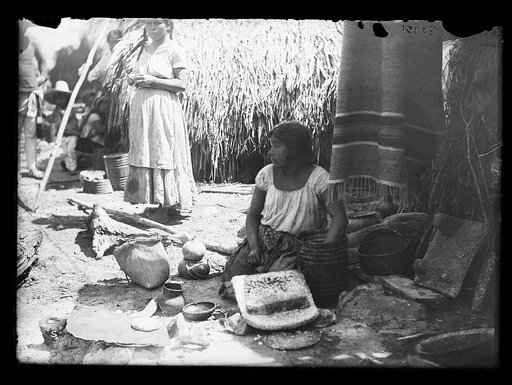 Woman with pottery at market, probably Mexico