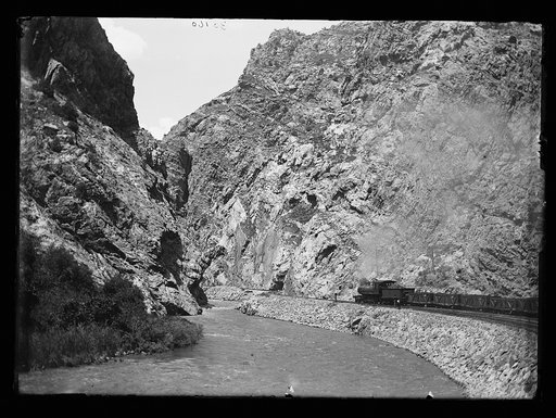 Train by river in steep canyon, probably Mexico