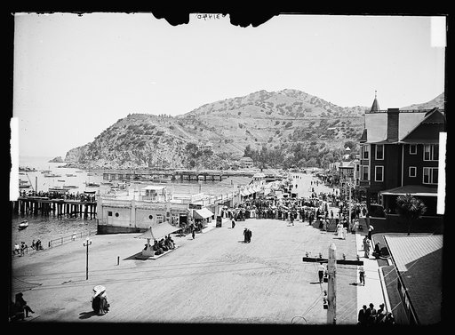 Crowds on boardwalk by aquarium, harbor, Avalon, Catalina Island, Calif.