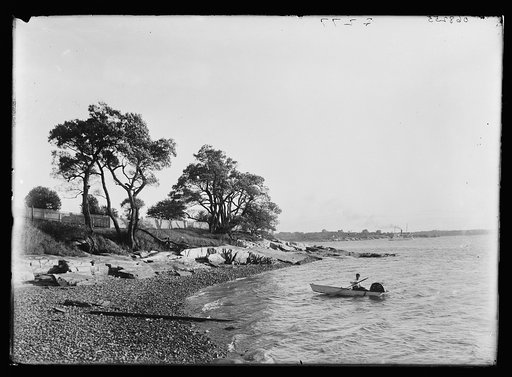 Man in boat with fish trap by beach