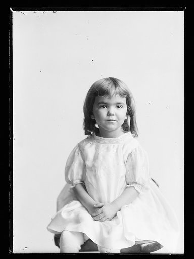 Girl in white dress, three-quarter-length portrait, seated