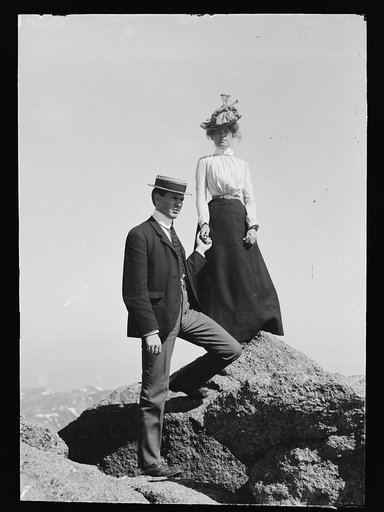 Young couple on rock holding hands, full-lengthportrait