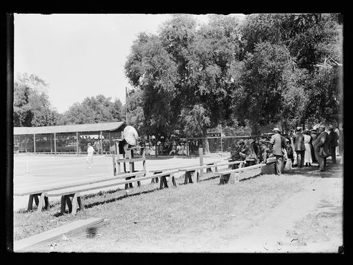 Tennis match with onlookers, possibly at resort