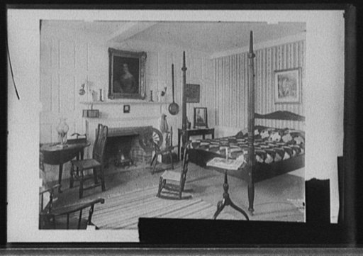 Bedroom with spinning wheel and Colonial-style furnishings