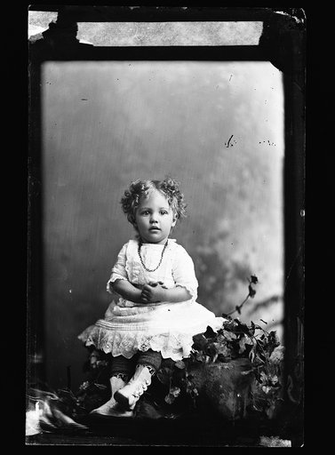 Louise Jackson, seated on rock in a studio, full-length portrait