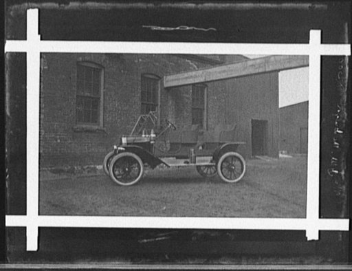 Two-seater automobile in front of industrial building