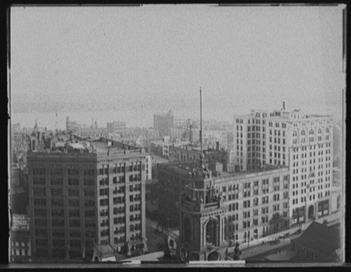 Church tower, commercial buildings and waterfront, probably Detroit