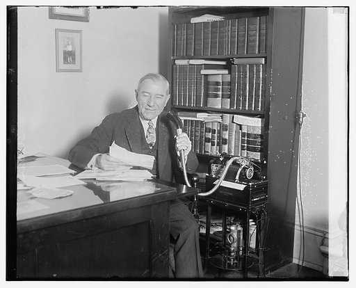 Unidentified man seated at desk with dictaphone