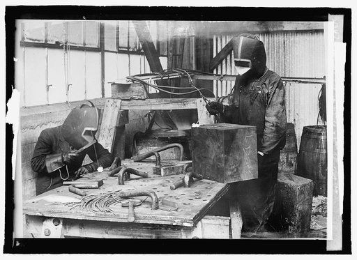 Cutting with acetylene flame, using masks & blue glass to protect the eyes