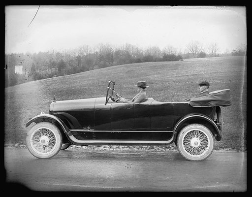 Woman driving automobile with man seated in back