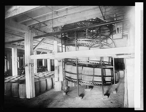 Spiral gravity boiler conveyor for handling barrels and boxes