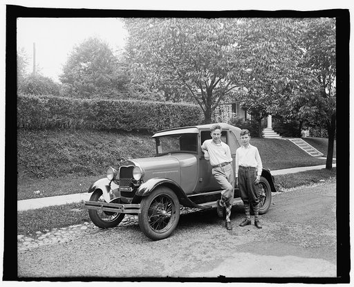 Boys standing next to automobile