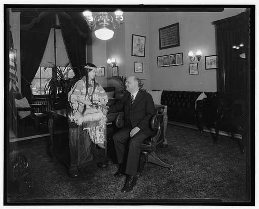 Girl with Native American clothing and man in office