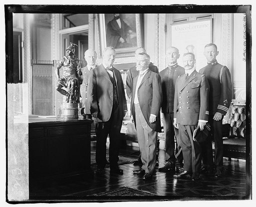 Secretary of the Navy, Josephus Daniels being presented a bronze statue by French Ambassador Jean Jusserand, for the U.S.S. Seattle, which escorted troop-ships to France. Front row, L. to R.: Secty. Daniels, Ambassador Jusserand, Capt. Sainte Seine; Back row, L. to R.: Adm. Wilson, Rear Adm. Niblack