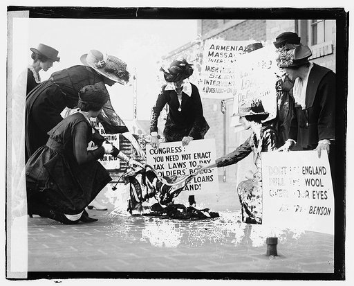 A group of women carrying signs against America's support of the English against the Irish, and burning a flag(?) on the sidewalk, June 3, 1920