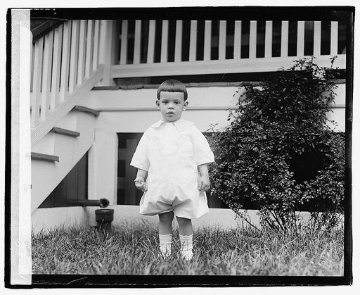 Unidentified child standing in front of porch