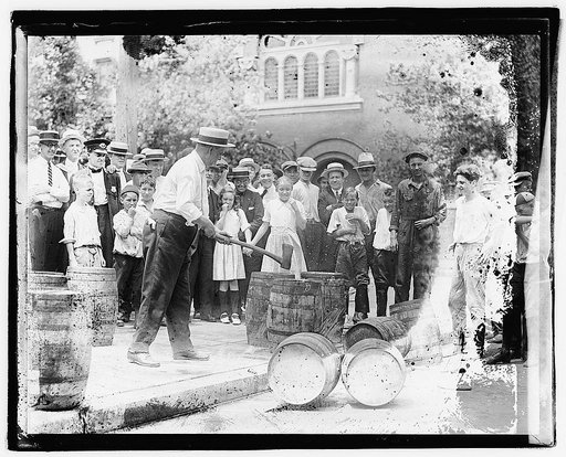 Man with ax breaking barrels on sidewalk,] 7/8/21