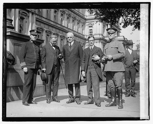 Daniels, Bishop McDowell and Baker, with two men in uniform standing in front of the old State Dept. building. One of them is looking in a little box. Oct. 4/20