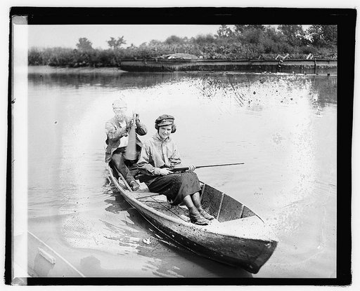 Unidentified man and woman with gun in canoe,] 8/1/21