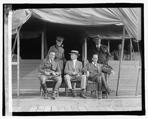 Five men outside tent building