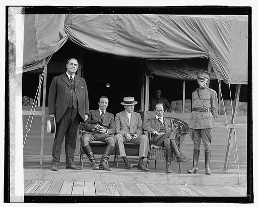 Five men outside tent building
