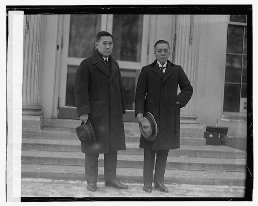 Two men standing by steps of building