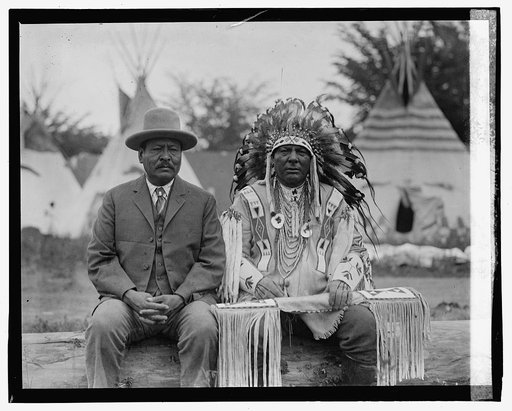 Two native american men, one in traditional dress