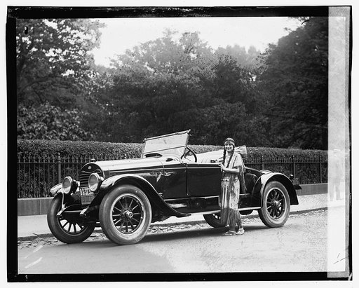 Woman wearing native american clothing next to automobile