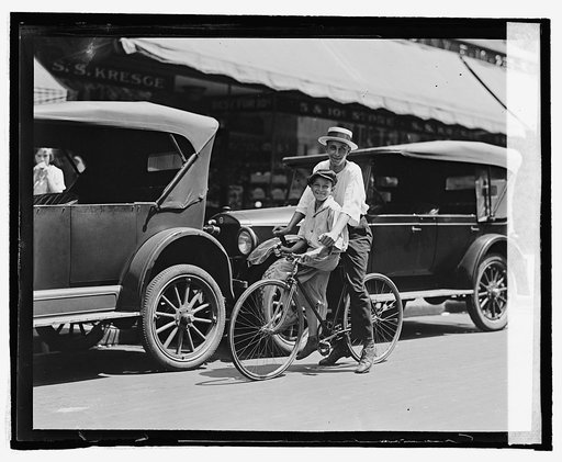 Street scene, two children on bicycle in front of S.S. Kresge, Washington, D.C.