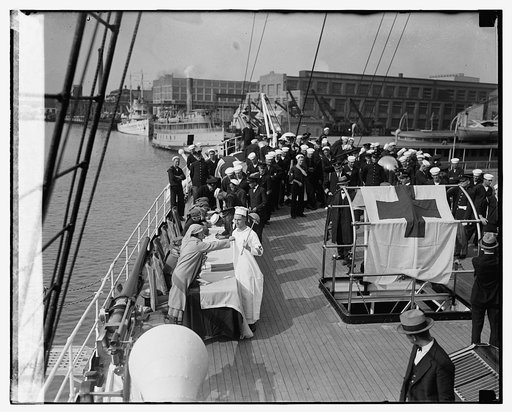 Miss Marjorie Wright pinning cross button on cook of Mayflower, 11/5/24