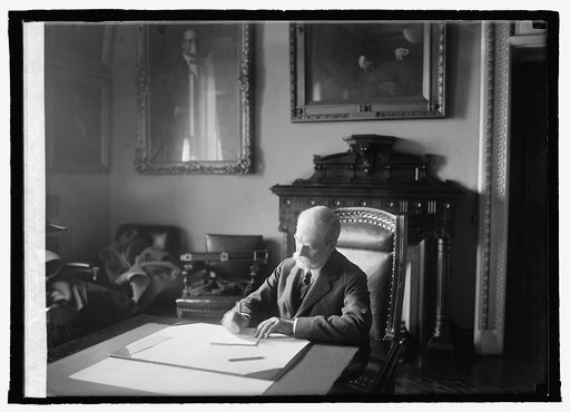Secty. Hughes at desk