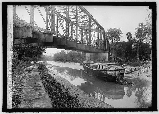 View of canal and bridge with boat "Canal Towage Co., No. 64