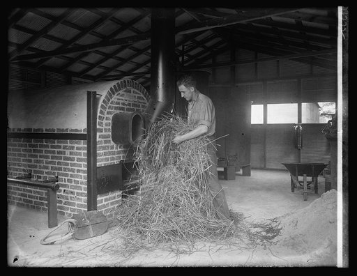 Man handling hay in industrial building