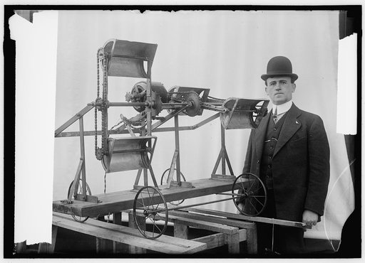 Man, possibly William B. Greene, with model for a machine that appears to be designed to scoop up material