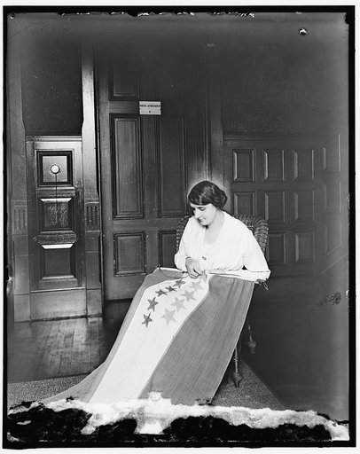 Sewing stars on suffrage flag