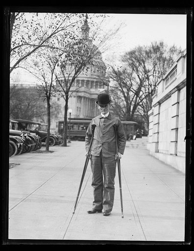 Man with crutches; U.S. Capitol in background. Washington, D.C.