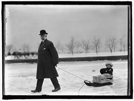 SKATING PARTY. UNIDENTIFIED MAN PULLING CHILD ON SLED