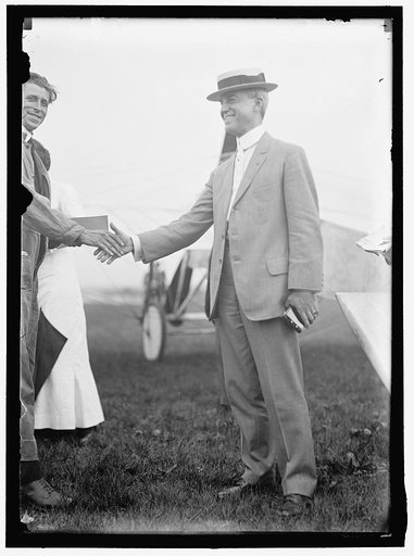 RUSSELL, EDGAR. MAJ., SIGNAL CORPS, U.S.A. RIGHT, SHAKING HANDS WITH AVIATOR WOOD
