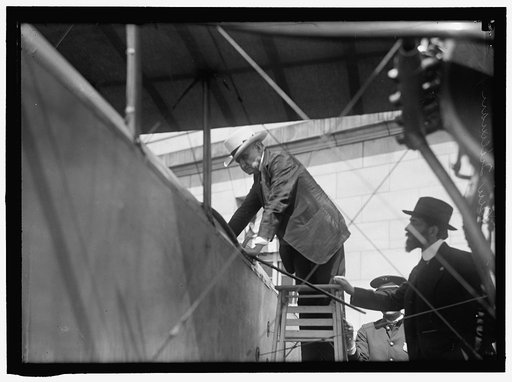 NATIONAL AERO COAST PATROL COMMN. CURTISS BIPLANE 2 ENGINES, WITH FLOATS, EXHIBITED AT S.O.B. SEN. BEN TILLMAN CLIMBING INTO PLANE; AUGUSTUS POST AT RIGHT