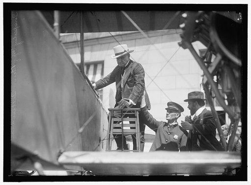 NATIONAL AERO COAST PATROL COMMN. CURTISS BIPLANE 2 ENGINES, WITH FLOATS, EXHIBITED AT S.O.B. SEN. BEN TILLMAN CLIMBING INTO PLANE; AUGUSTUS POST AT RIGHT