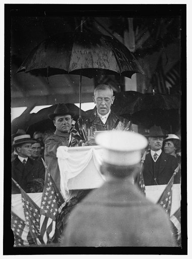 FLAG DAY. WILSON MAKING ADDRESS IN RAIN. LANSING 2ND FROM RIGHT