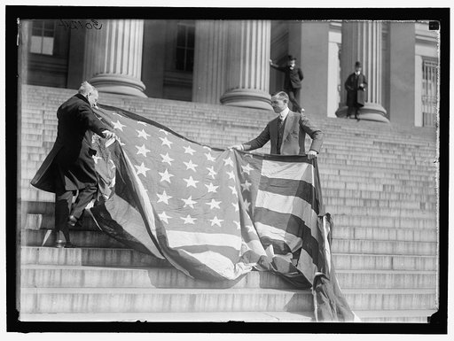 LIBERTY LOANS. CARTER GLASS AND F.R. WILSON WITH CAPITOL FLAG ON TREASURY STEPS