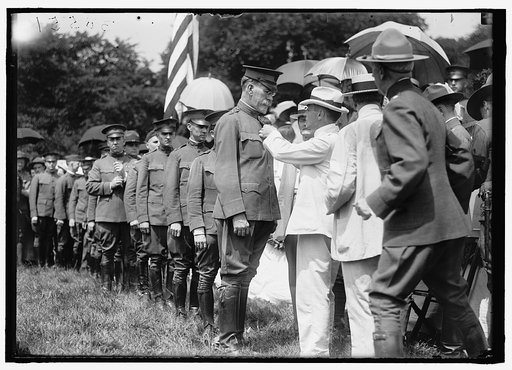 HARVEY, WILLIAM E. COLONEL, N. A. BEING DECORATED BY SEC. BAKER