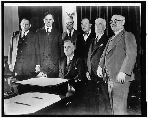 Congressional beer crusaders witness signing of beer bill. Members of Congress today witnessed the actual signing of their hard fought battle for legalized beer. Surrounding President Roosevelt at his desk in the Cabinet Room are, left to right: Representatives Claude V. Parsons of Illinois; John W.