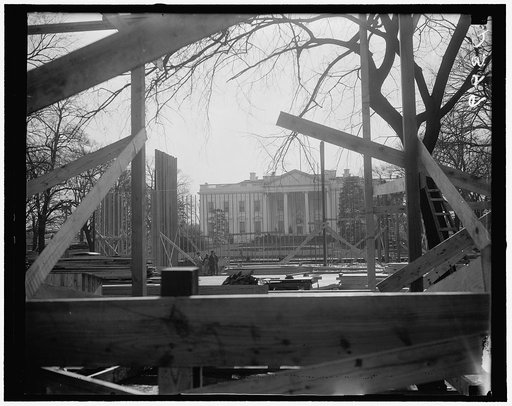 Construction of Inaugural stands in Court of Honor started. Washington, D.C., Dec. 23. A view of the White House through the construction work of the Court of Honor inaugural stands. Directly opposite these stands will be the President's reviewing stand
