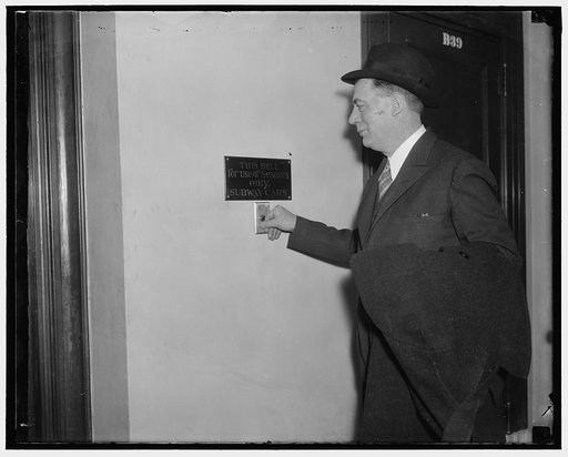 Rookie Senator belives in signs. Washington, D.C., Jan. 5. Rookie Senator Ed. C. Johnson, Democrat of Colorado, signals the Capitol elevator on way to attend the opening session of the 75th Congress which convened today