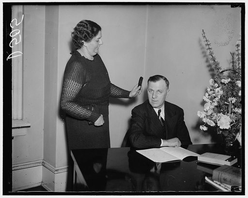 Making the boss ready. Washington, D.C., Jan. 7. Rep. Michael Kirwan, new Democratic member of the House from Ohio, is given the final touch from his Secretary, Mrs. Roberta Messerly, before posing for the cameramen